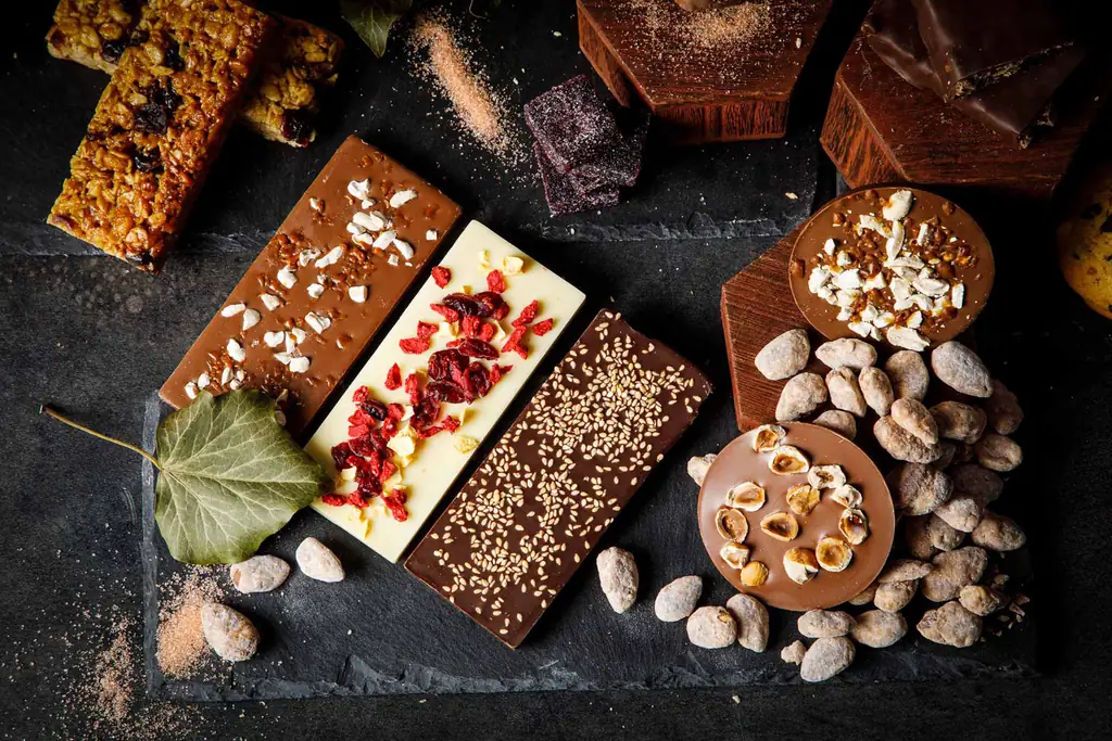 Plaques de chocolat aux fruits rouges et au sésame, fèves de cacao et noisettes